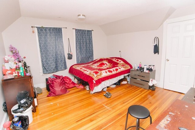 bedroom featuring wood finished floors and vaulted ceiling