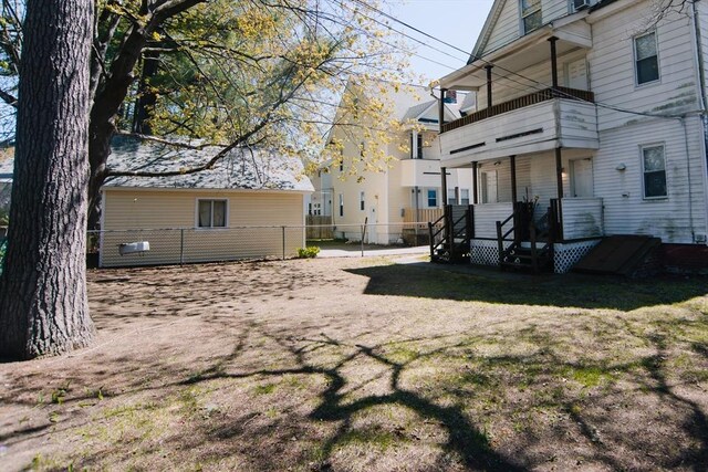 view of yard featuring fence and a balcony