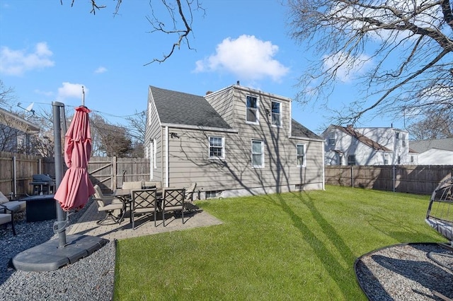 rear view of property with a yard, a shingled roof, a fenced backyard, and a patio area