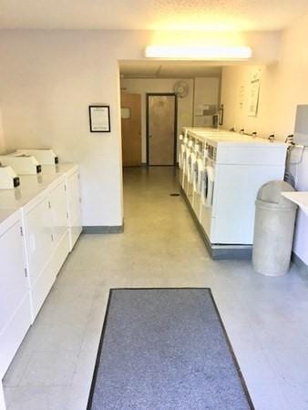 10 Williams St Unit 79, Watertown, MA 02472 - shared laundry featuring washing machine and dryer, light flooring, and baseboards