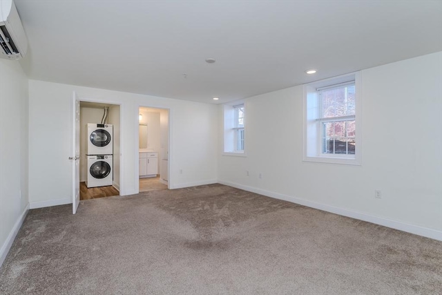 interior space featuring an AC wall unit, connected bathroom, light colored carpet, and stacked washer / drying machine