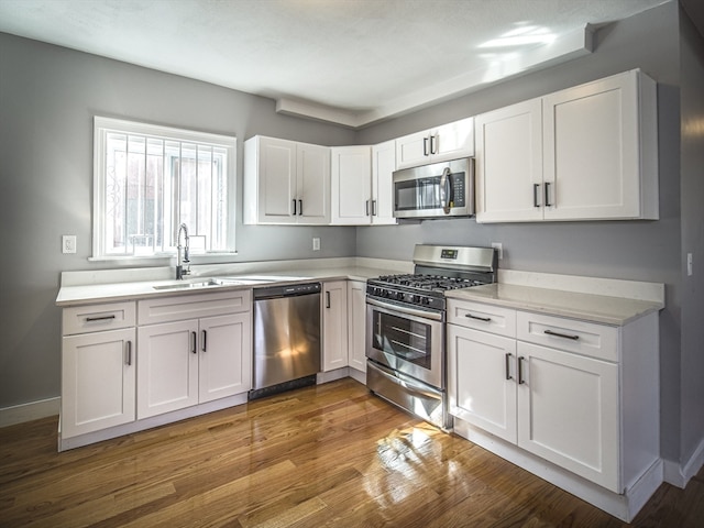 kitchen with sink, white cabinets, stainless steel appliances, and dark hardwood / wood-style floors