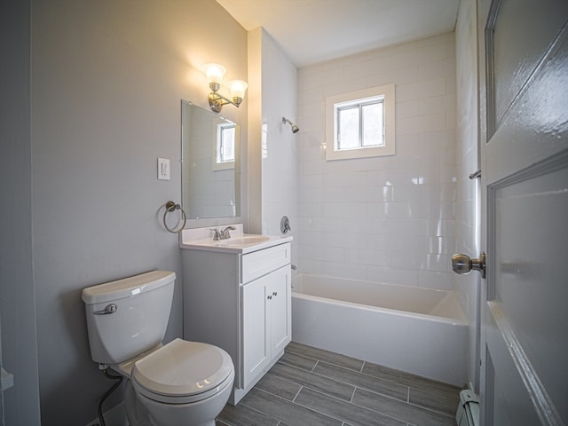 full bathroom with baseboard heating, vanity, tiled shower / bath combo, and toilet