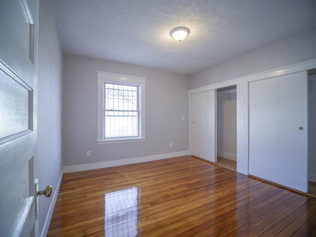 unfurnished bedroom featuring hardwood / wood-style flooring and a textured ceiling