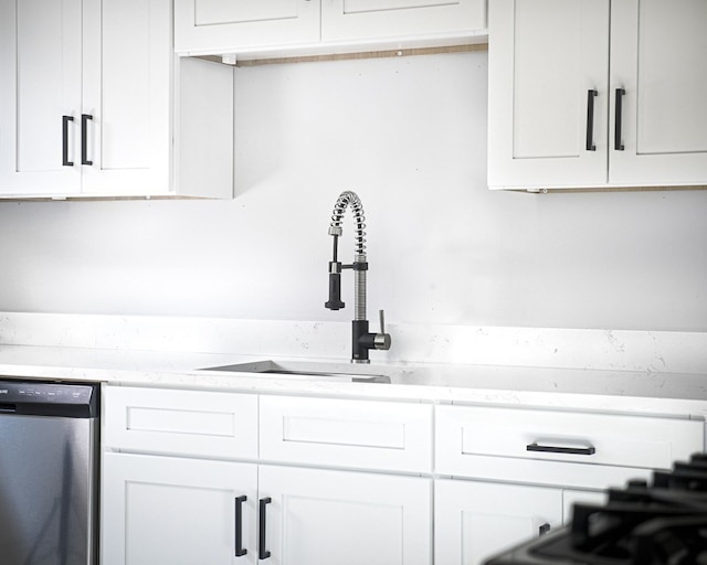 interior space featuring white cabinets, dishwasher, and sink