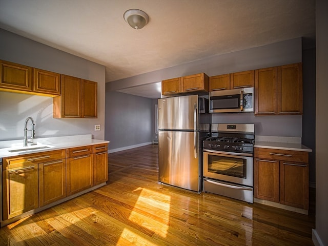 kitchen with sink, light hardwood / wood-style floors, and appliances with stainless steel finishes