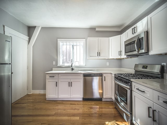 kitchen with sink, white cabinets, stainless steel appliances, and dark hardwood / wood-style floors