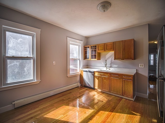 kitchen featuring sink, stainless steel appliances, light wood-type flooring, and a baseboard heating unit