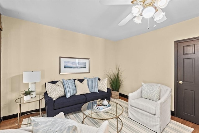 living room featuring a ceiling fan, light wood-style flooring, and baseboards