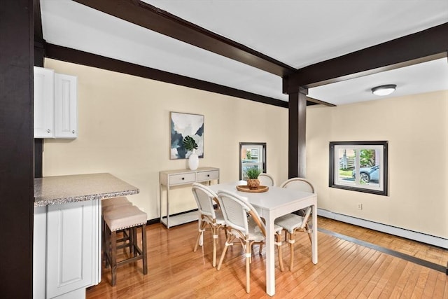 dining area featuring light wood-style floors, beam ceiling, a baseboard heating unit, and baseboards