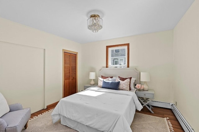 bedroom with a baseboard radiator and wood finished floors