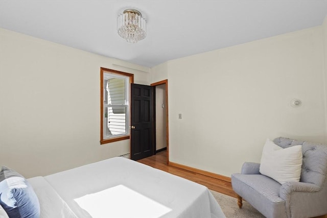 bedroom with a notable chandelier and wood finished floors