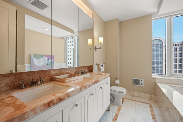 bathroom featuring toilet, a bathing tub, and vanity