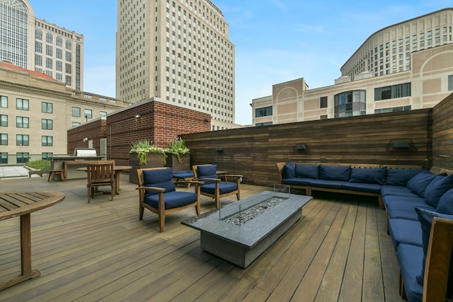 deck featuring an outdoor living space with a fire pit