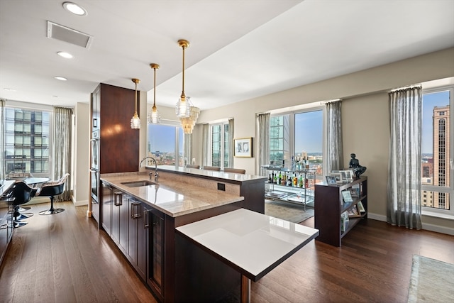 kitchen featuring pendant lighting, a wealth of natural light, dark hardwood / wood-style floors, and sink