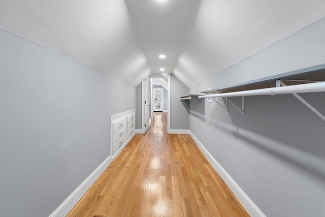 spacious closet featuring lofted ceiling and light wood-type flooring