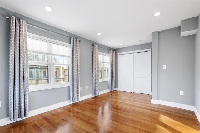 unfurnished bedroom featuring a closet and hardwood / wood-style flooring