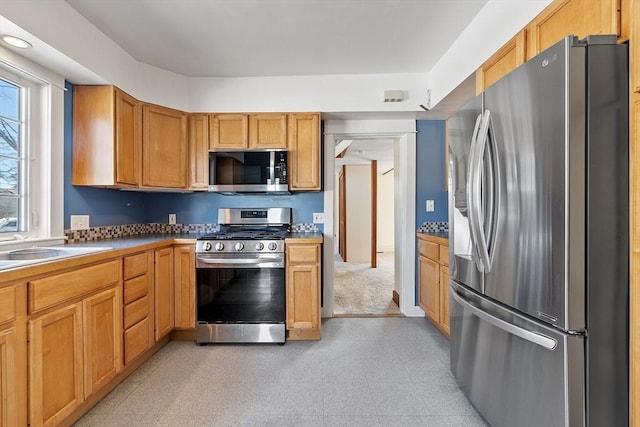 kitchen featuring appliances with stainless steel finishes, a sink, and light floors