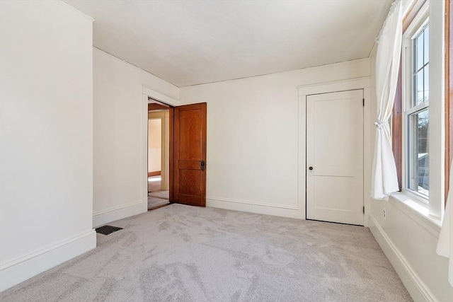 carpeted spare room featuring visible vents and baseboards