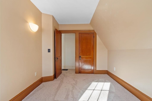 additional living space featuring carpet floors, baseboards, and lofted ceiling