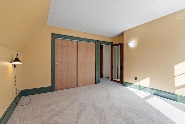 unfurnished bedroom featuring carpet floors, two closets, and lofted ceiling