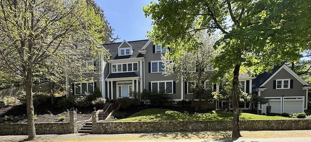 view of front of house with stairway, a front lawn, and an attached garage