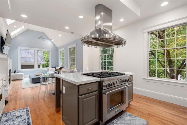 kitchen featuring high end stove, island exhaust hood, plenty of natural light, open floor plan, and recessed lighting