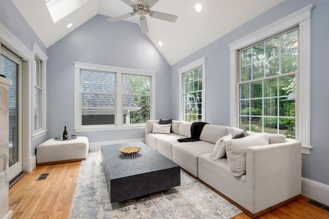 living room with a skylight, recessed lighting, wood finished floors, a ceiling fan, and baseboards