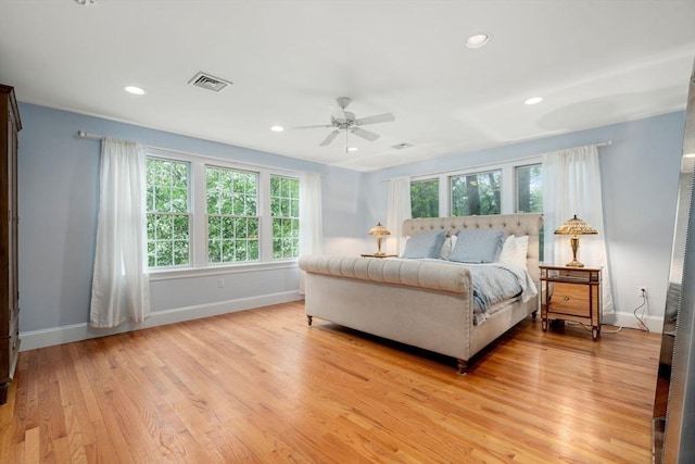 bedroom with baseboards, multiple windows, light wood-style flooring, and recessed lighting