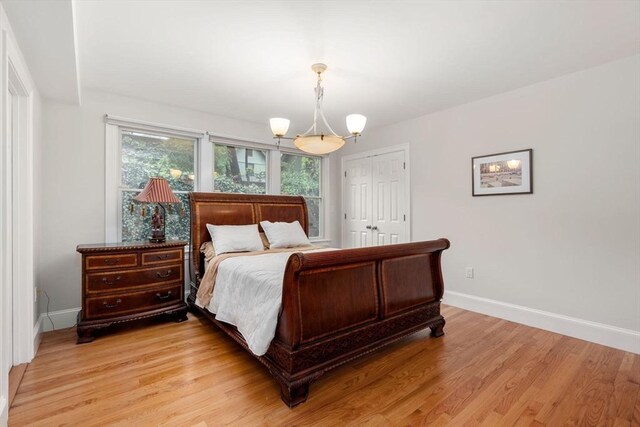 bedroom with baseboards, light wood-style flooring, and a closet
