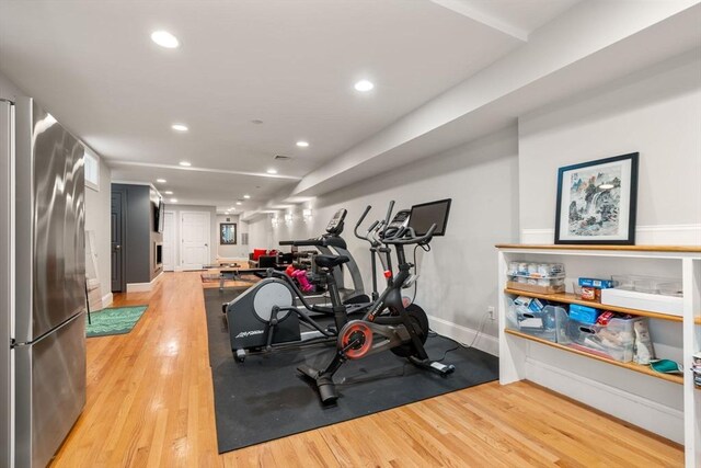 workout room with light wood-style floors, recessed lighting, and baseboards