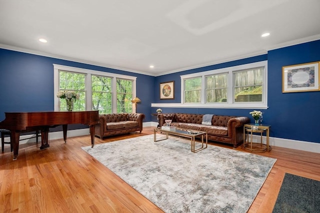 living room with ornamental molding, baseboards, recessed lighting, and light wood-type flooring