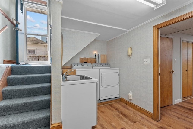 washroom with crown molding, laundry area, separate washer and dryer, baseboards, and light wood-type flooring