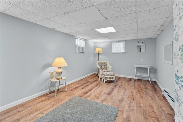 sitting room featuring baseboards, a paneled ceiling, wood finished floors, and baseboard heating