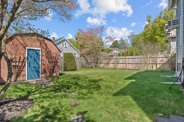 view of yard with a fenced backyard, a shed, and an outbuilding