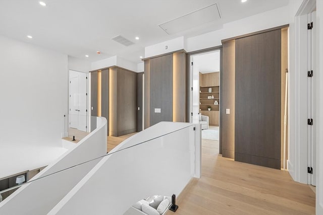 hallway featuring visible vents, recessed lighting, an upstairs landing, and light wood-style floors