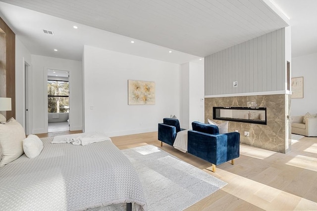 bedroom featuring recessed lighting, a fireplace, visible vents, baseboards, and light wood finished floors