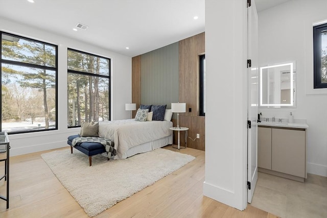 bedroom featuring baseboards, light wood finished floors, visible vents, and recessed lighting