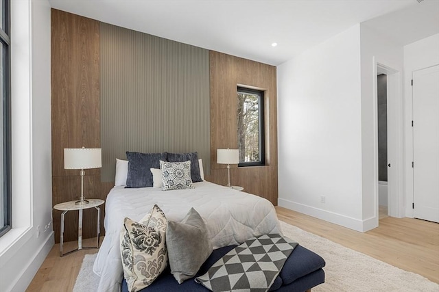 bedroom with light wood finished floors and baseboards