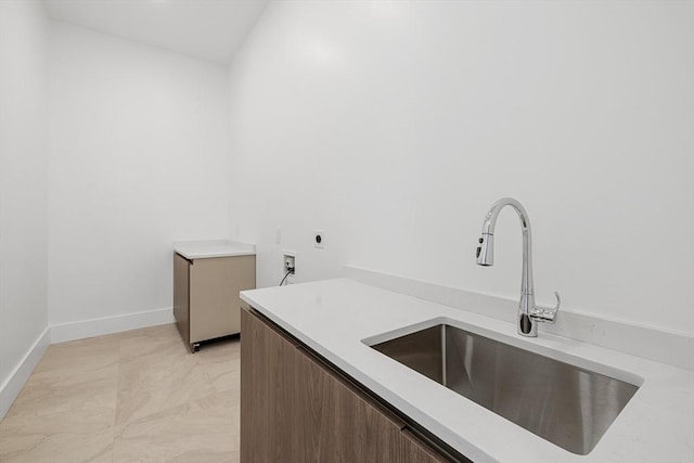 washroom featuring hookup for a washing machine, hookup for an electric dryer, laundry area, a sink, and baseboards