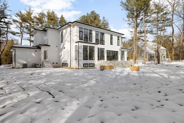 snow covered property featuring stucco siding