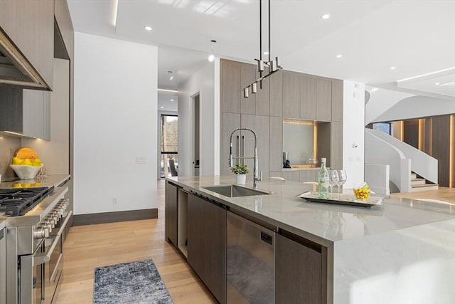 kitchen featuring light stone counters, decorative light fixtures, a sink, and modern cabinets