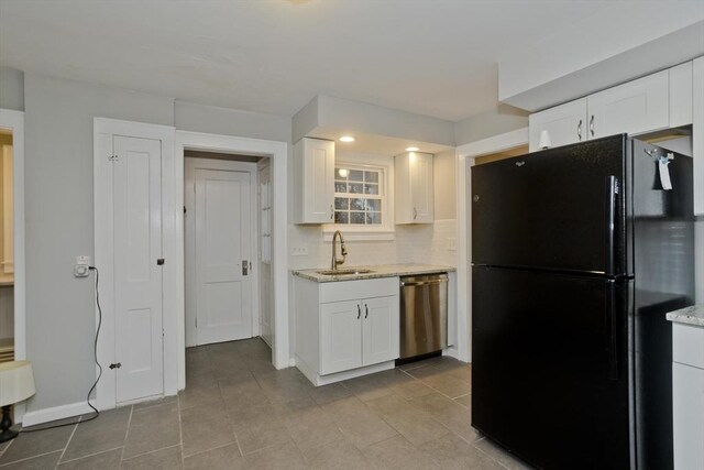 kitchen with a sink, stainless steel dishwasher, white cabinets, and freestanding refrigerator