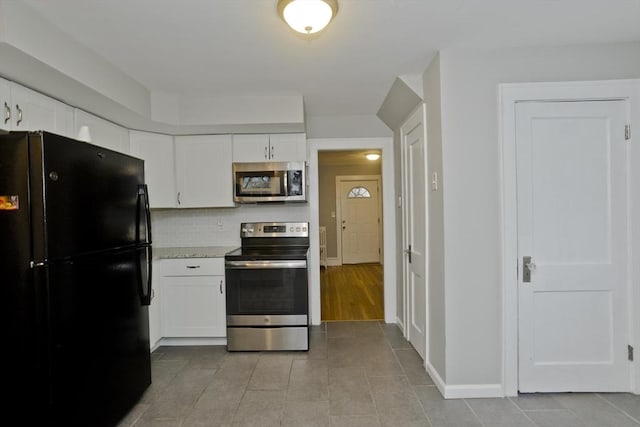 kitchen featuring baseboards, light countertops, decorative backsplash, appliances with stainless steel finishes, and white cabinets