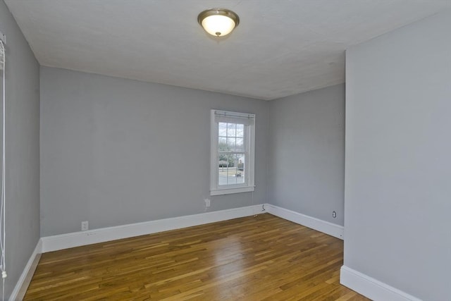 empty room with baseboards and wood finished floors