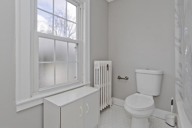 full bathroom with curtained shower, baseboards, radiator, and toilet