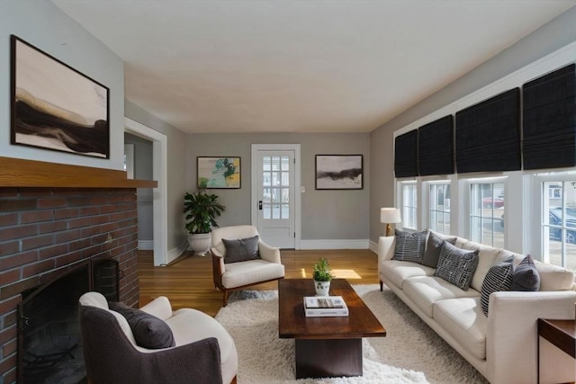 living room featuring wood finished floors, a fireplace, and baseboards