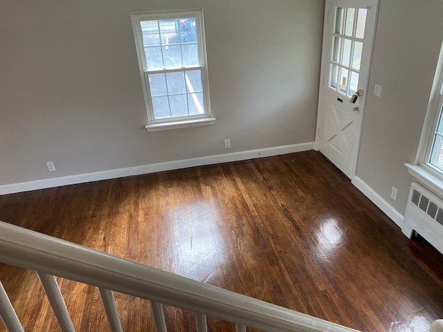 entryway with radiator heating unit and dark wood-type flooring