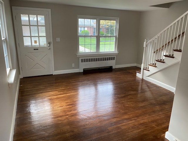 foyer with radiator, a healthy amount of sunlight, and dark hardwood / wood-style flooring