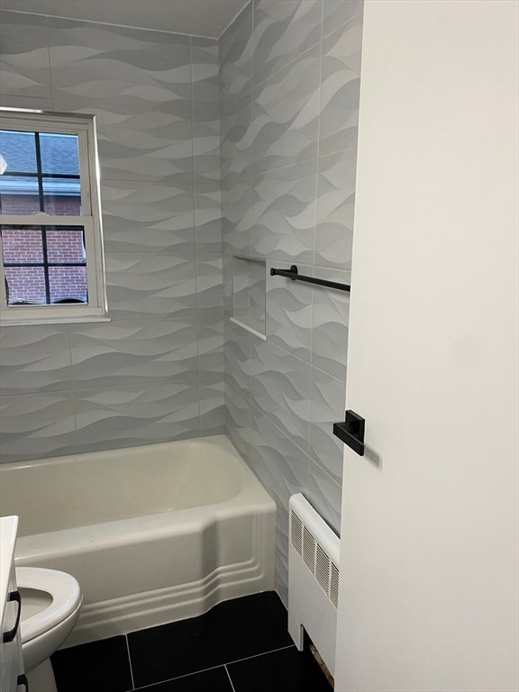 full bathroom with vanity, tile patterned flooring, radiator, toilet, and tiled shower / bath